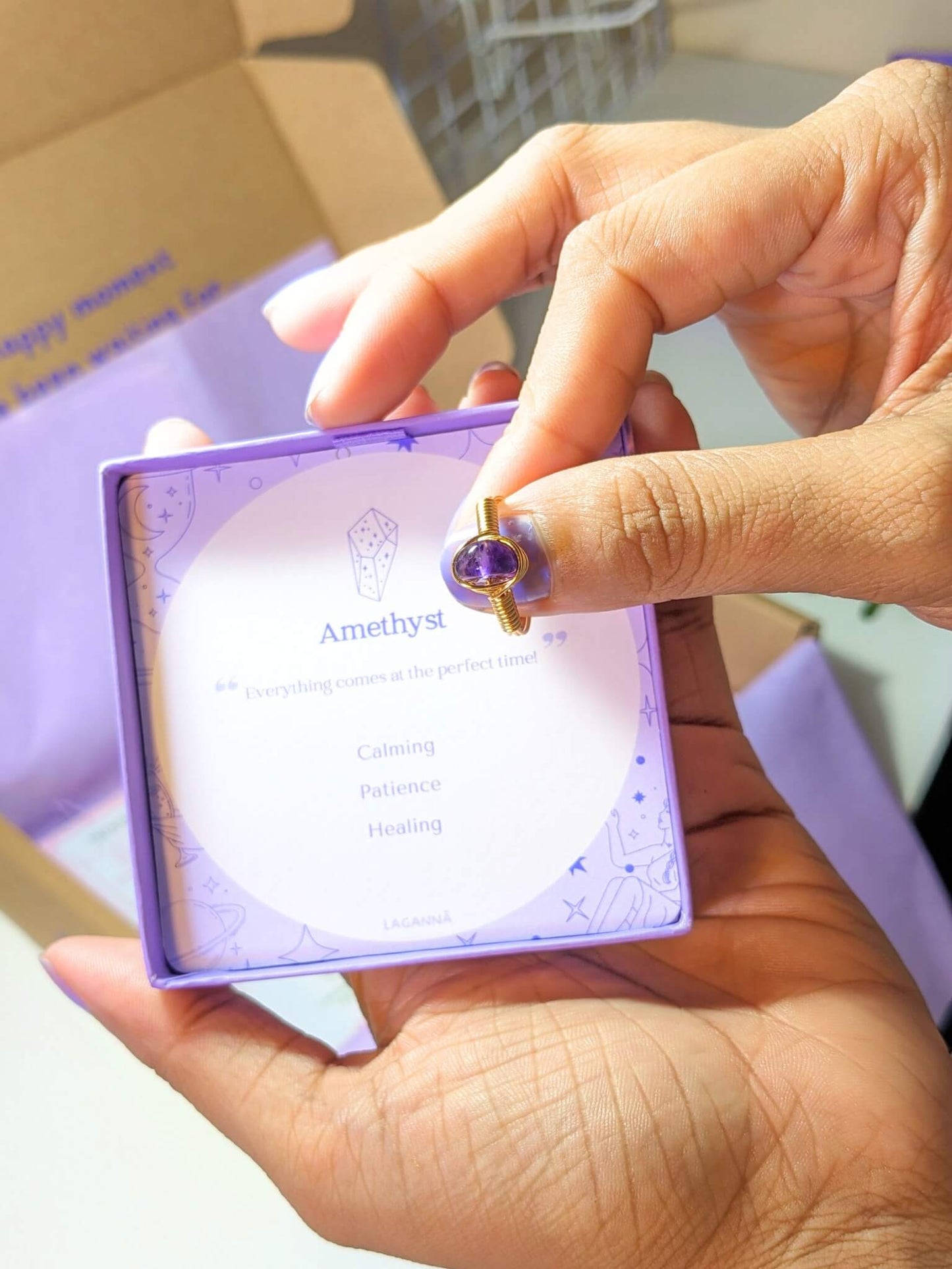 Amethyst irregular stone ring holding on hand showing handmade gold wire wrapped healing crystal jewelry lifestyle, Sri Lankan spiritual ring featuring natural purple gemstone perfect as boho meditation ring and protective amulet for stress relief and spiritual awakening