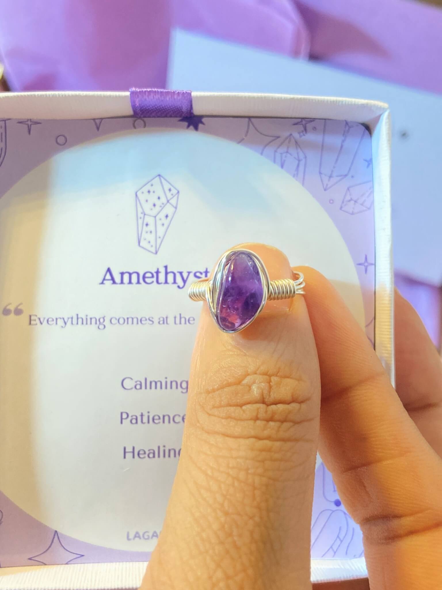 Amethyst irregular stone ring in silver wire wrapped design with jewelry box held in hand showing handmade healing crystal gift set, Sri Lankan artisan spiritual ring featuring natural purple gemstone perfect as third eye chakra jewelry gift for stress relief and spiritual awakening