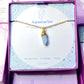 Aquamarine irregular stone necklace jewelry box front view showing gold wire wrapped design, handmade Sri Lankan healing crystal pendant for clarity and calm
