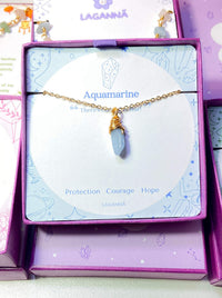 Aquamarine irregular stone necklace jewelry box front view showing gold wire wrapped design, handmade Sri Lankan healing crystal pendant for clarity and calm