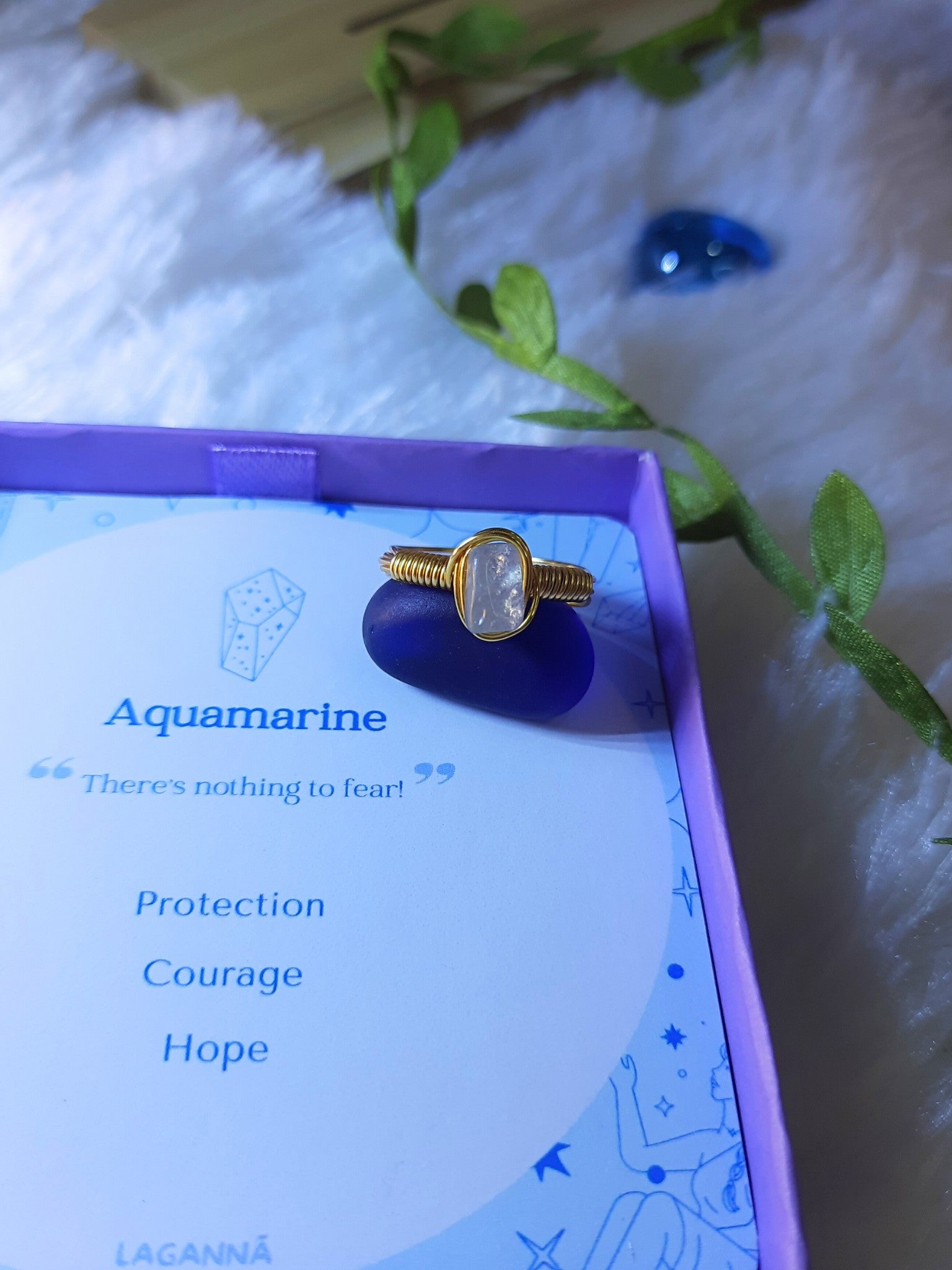 Aquamarine irregular stone ring in elegant jewelry box showing handmade gold wire wrapped healing crystal gift set, Sri Lankan artisan spiritual ring featuring natural blue gemstone perfect as throat chakra jewelry gift for clarity and emotional healing with premium packaging