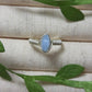 Natural aquamarine irregular stone ring in silver wire wrapped design on jewelry display showing handmade healing crystal jewelry, Sri Lankan artisan spiritual ring with raw blue gemstone perfect as boho throat chakra ring and protective amulet for communication and tranquility
