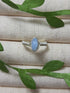 Natural aquamarine irregular stone ring in silver wire wrapped design on jewelry display showing handmade healing crystal jewelry, Sri Lankan artisan spiritual ring with raw blue gemstone perfect as boho throat chakra ring and protective amulet for communication and tranquility
