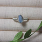 Handmade aquamarine irregular stone ring in silver wire wrapped design on jewelry display featuring natural healing crystal jewelry, Sri Lankan artisan throat chakra ring with raw blue gemstone perfect as boho communication ring and protective amulet for clarity and peace