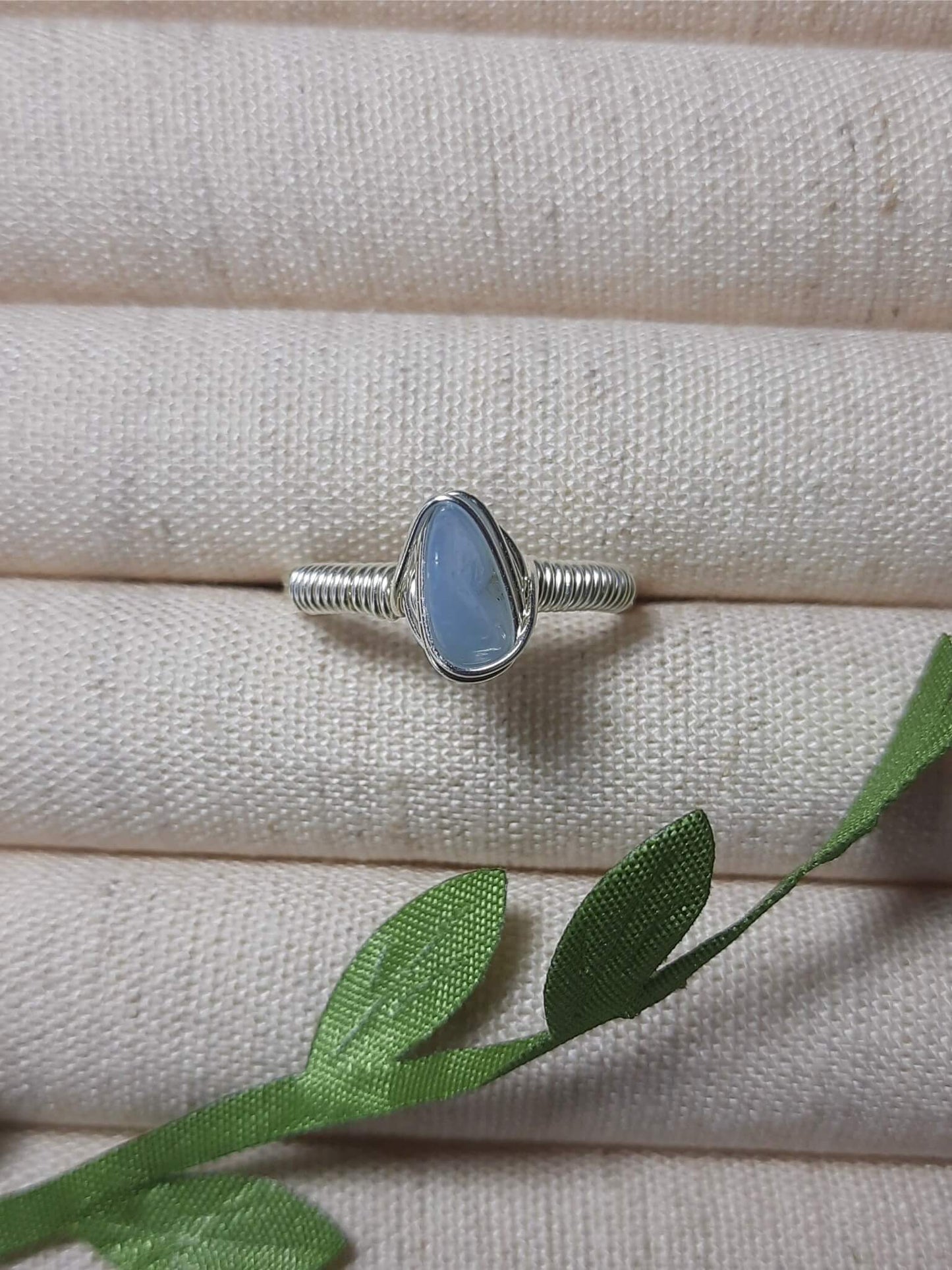 Handmade aquamarine irregular stone ring in silver wire wrapped design on jewelry display featuring natural healing crystal jewelry, Sri Lankan artisan throat chakra ring with raw blue gemstone perfect as boho communication ring and protective amulet for clarity and peace