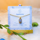 Handmade aquamarine square stone necklace in gold wire wrapped design on jewelry card featuring natural healing crystal jewelry crafted by Sri Lankan artisans as throat chakra balancing pendant and communication enhancement amulet for women seeking clarity and emotional healing with geometric blue gemstone
