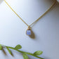 Aquamarine square stone necklace on jewelry display showing handmade gold wire wrapped healing crystal jewelry, Sri Lankan artisan throat chakra pendant featuring natural square blue gemstone perfect as boho communication necklace and clarity amulet for meditation and spiritual growth