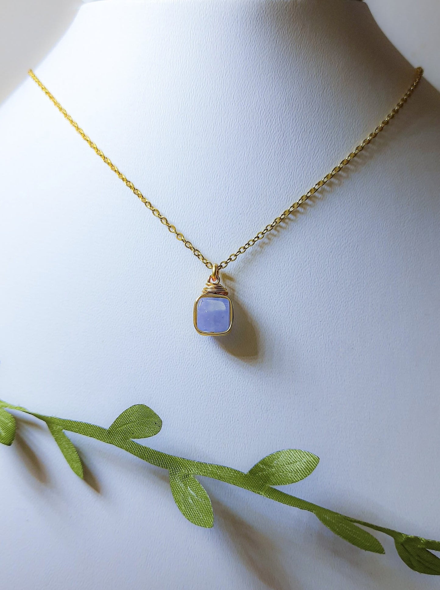 Aquamarine square stone necklace on jewelry display showing handmade gold wire wrapped healing crystal jewelry, Sri Lankan artisan throat chakra pendant featuring natural square blue gemstone perfect as boho communication necklace and clarity amulet for meditation and spiritual growth