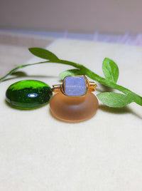 Handmade aquamarine square stone ring in gold wire wrap on jewelry display, Sri Lankan healing crystal jewelry for throat chakra balancing and communication enhancement