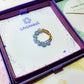 Blue chalcedony braided ring jewelry box closeup, handmade Sri Lankan gold wire wrapped healing crystal ring for communication and emotional balance