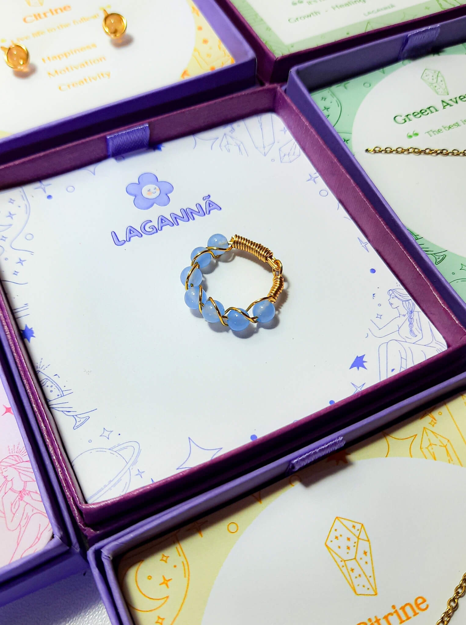 Blue chalcedony braided ring jewelry box closeup, handmade Sri Lankan gold wire wrapped healing crystal ring for communication and emotional balance