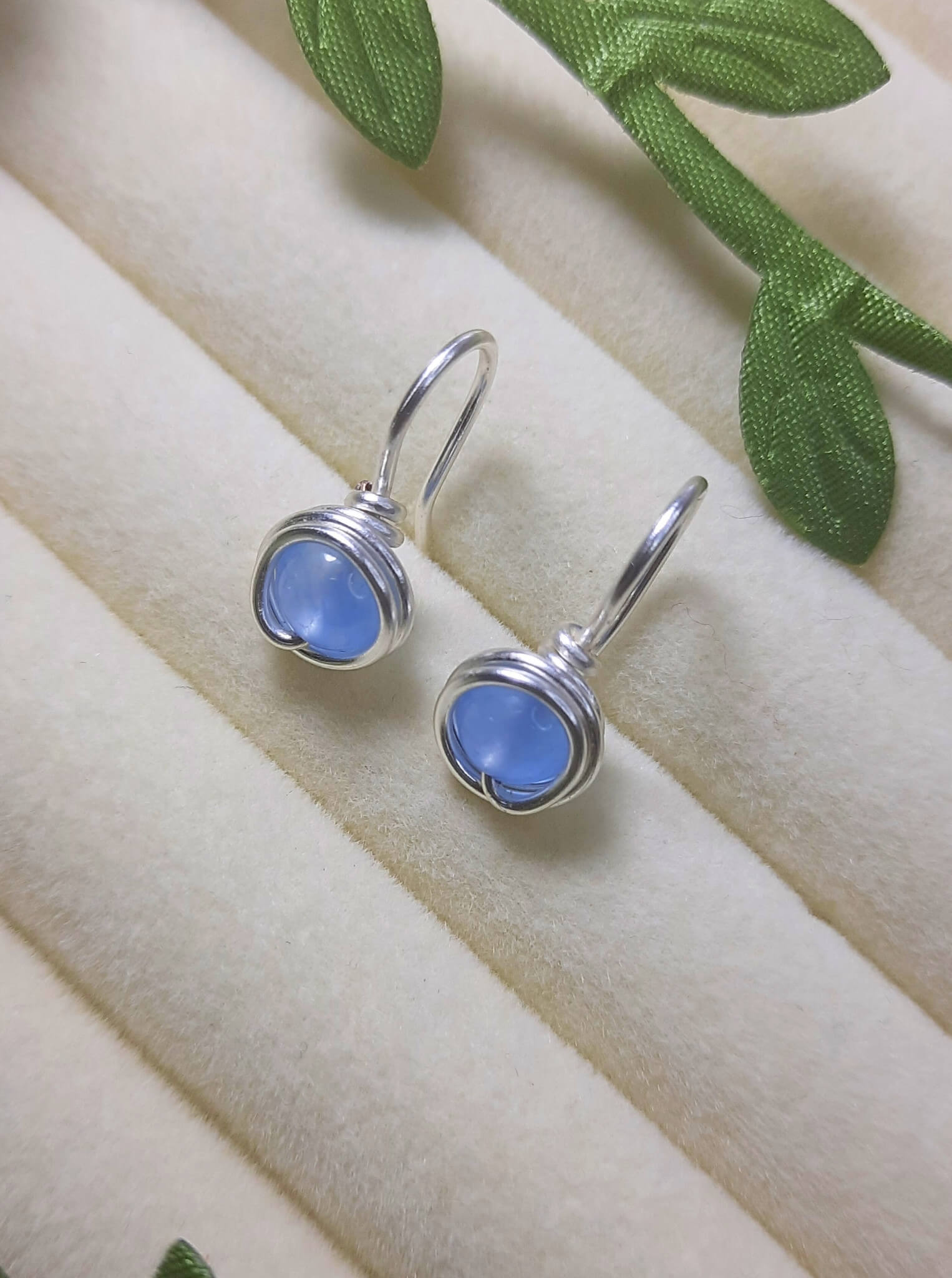 Close-up macro shot of Blue Chalcedony round stone showing translucent soft blue color and smooth polished surface - natural gemstone for calm and serenity in handmade Sri Lankan jewelry
