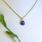 Gold blue evil eye protection necklace with natural green leaves showcasing adjustable spiritual pendant jewelry, handmade Sri Lankan healing crystal necklace with wire wrapped design perfect as boho evil eye talisman and protective amulet for nature-loving metaphysical enthusiasts