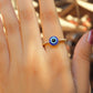 Blue evil eye ring worn on hand showing adjustable gold protection jewelry, handmade Sri Lankan spiritual ring with wire wrapped healing crystal design perfect as boho evil eye talisman and protective amulet for metaphysical jewelry lovers