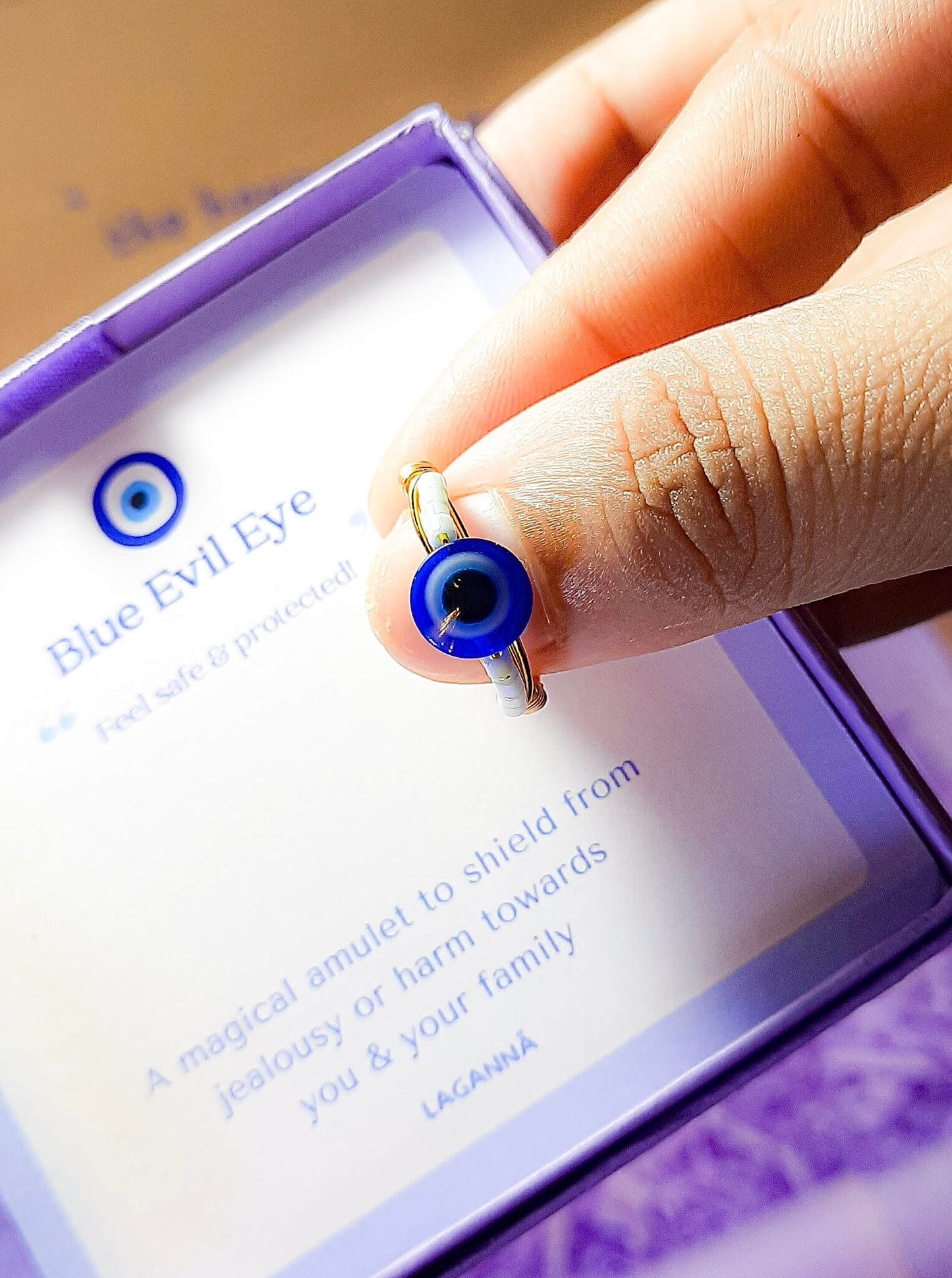 Blue evil eye seed bead ring jewelry box held on hand, handmade Sri Lankan gold wire wrapped protective talisman ring gift for spiritual protection