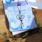 Blue Moon Jellyfish Necklace handmade stainless steel wire jellyfish pendant with Blue Chalcedony on Laganna packaging card angled view wooden surface artisan crafted Sri Lanka healing crystal jewelry tarnish resistant water resistant