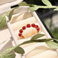Carnelian braided ring in gold wire wrap resting in a jewelry box, handmade Sri Lankan healing crystal ring for confidence and inner strength