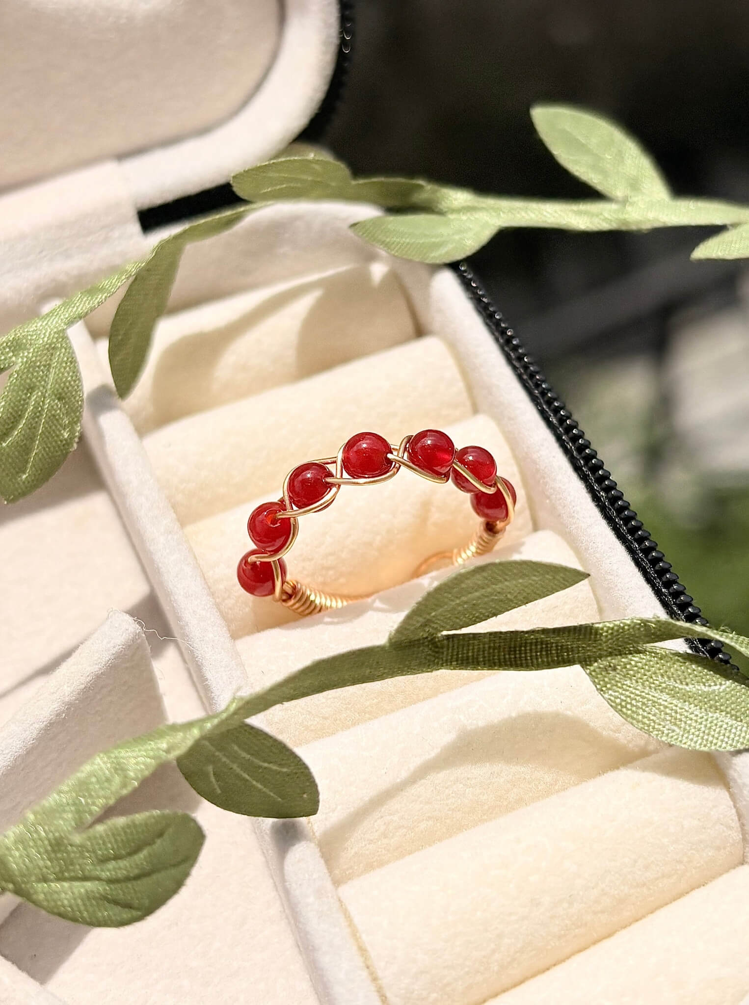 Carnelian braided ring in gold wire wrap resting in a jewelry box, handmade Sri Lankan healing crystal ring for confidence and inner strength