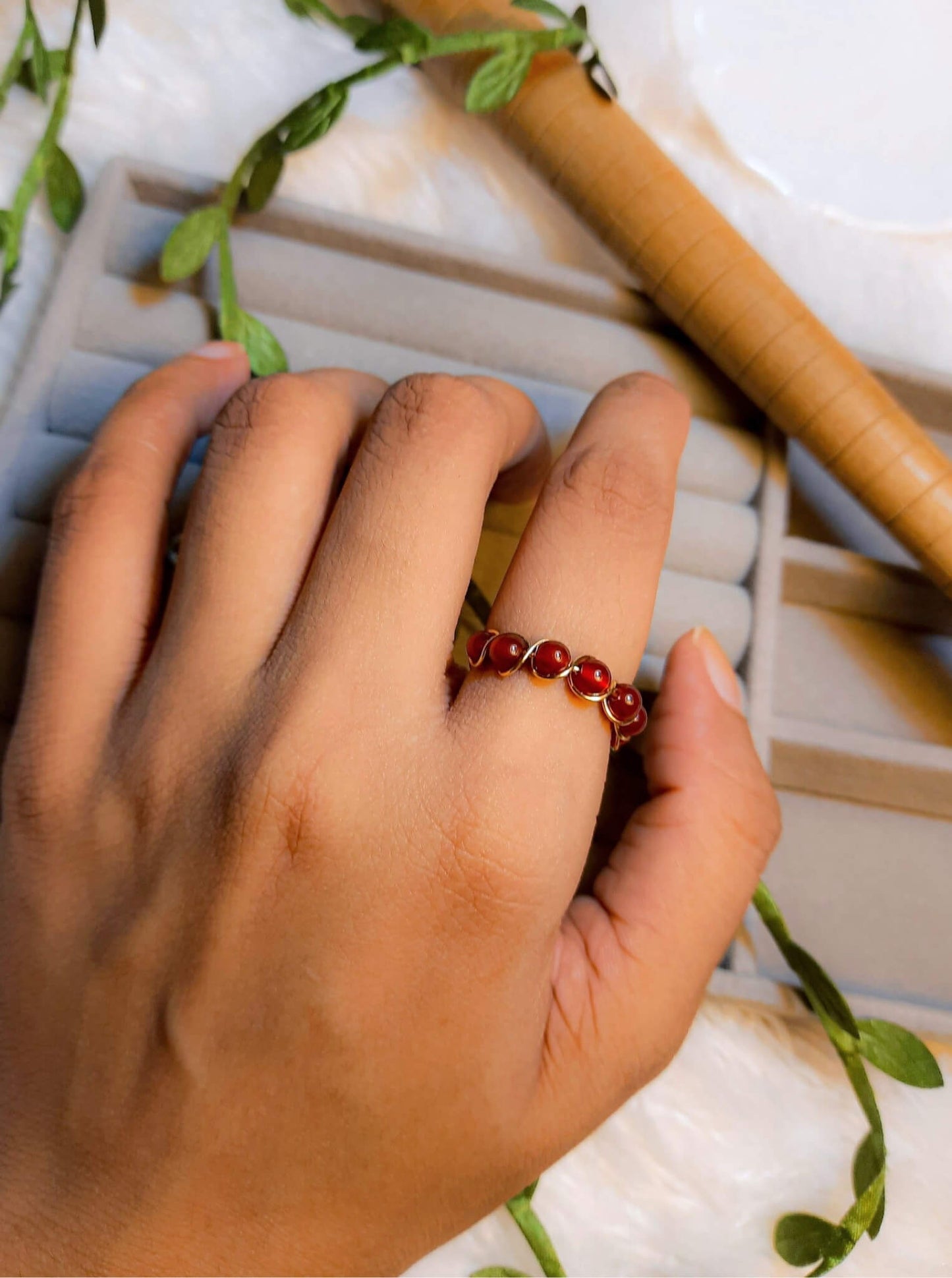 Carnelian braided ring worn on hand showing gold wire wrapped design, handmade Sri Lankan healing crystal ring lifestyle for confidence and motivation