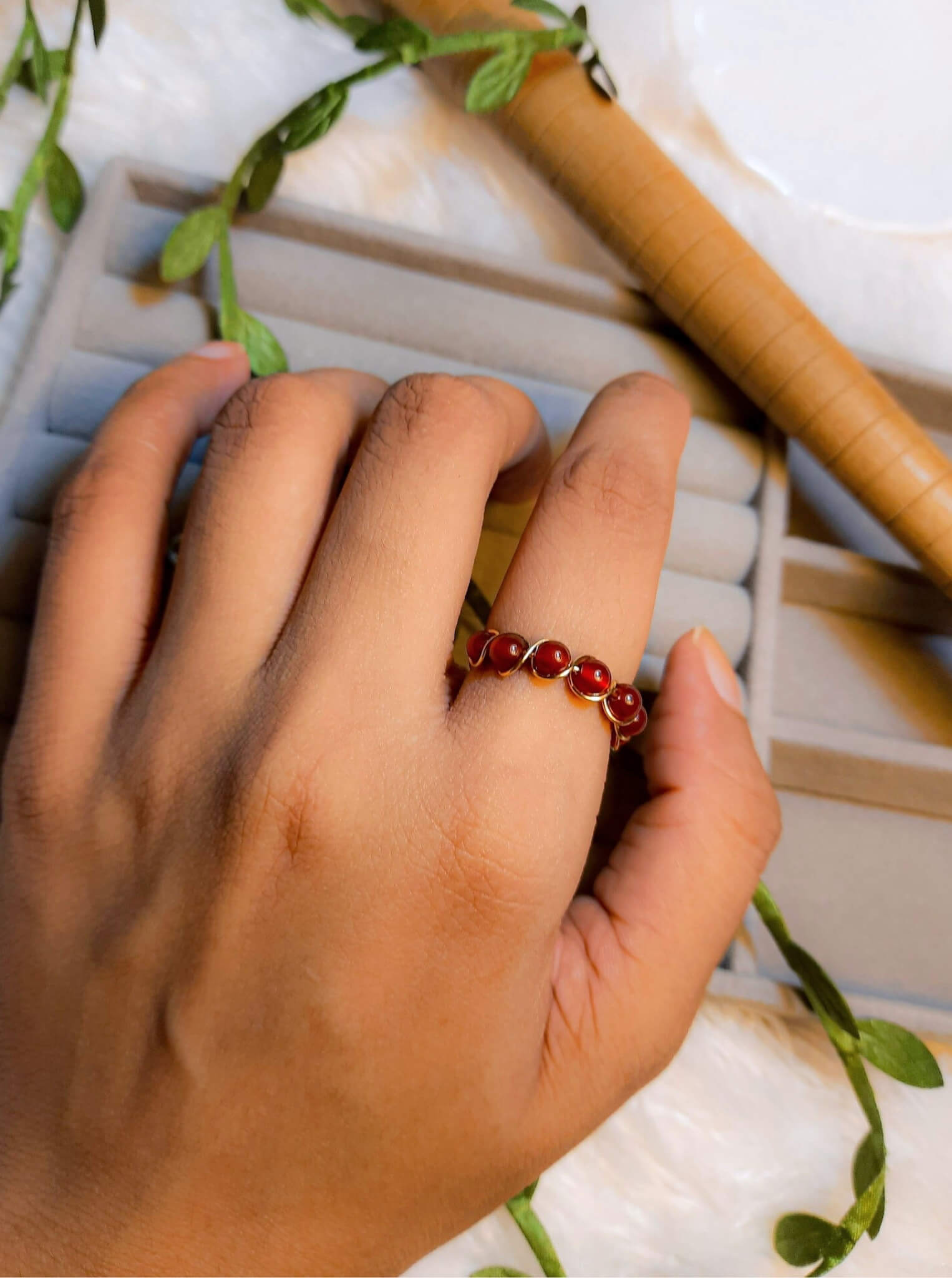 Carnelian braided ring worn on hand showing gold wire wrapped design, handmade Sri Lankan healing crystal ring lifestyle for confidence and motivation