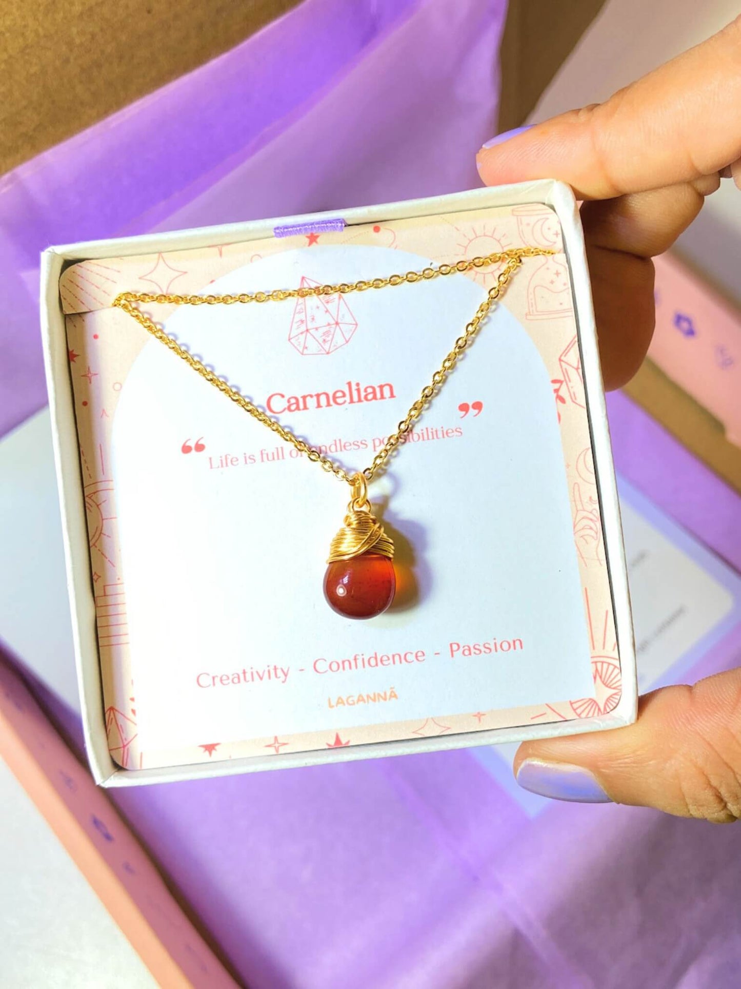 Carnelian drop necklace with elegant Laganna jewelry box held in hand showing premium packaging, handmade gold healing crystal pendant gift set featuring Sri Lankan artisan spiritual jewelry perfect as gemstone statement necklace gift for confidence and creativity