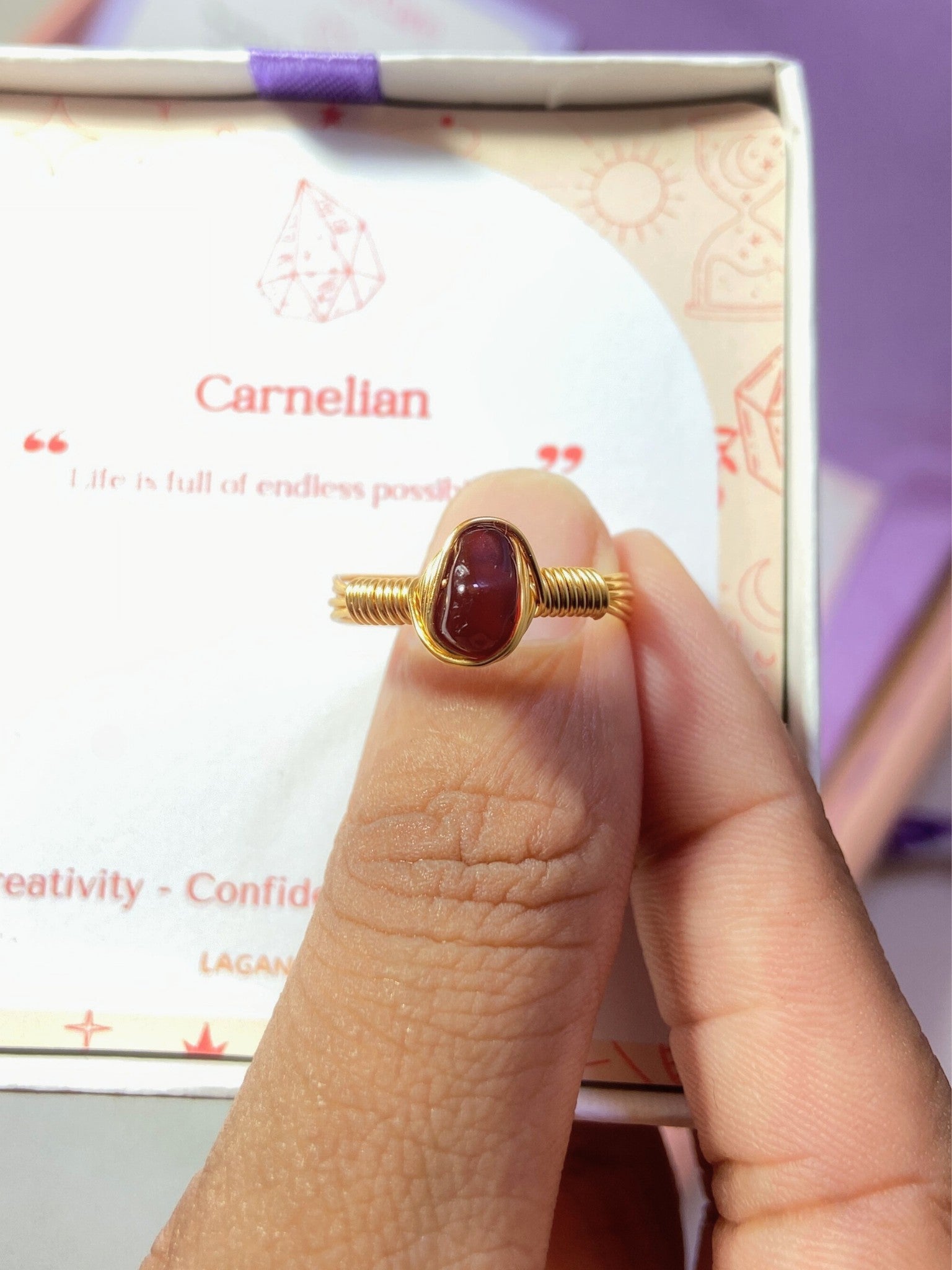 Carnelian irregular stone ring jewelry box held in hand showing handmade gold wire wrapped healing crystal gift set, Sri Lankan artisan creativity stone ring featuring natural orange gemstone perfect as courage jewelry gift for motivation and confidence enhancement with premium packaging