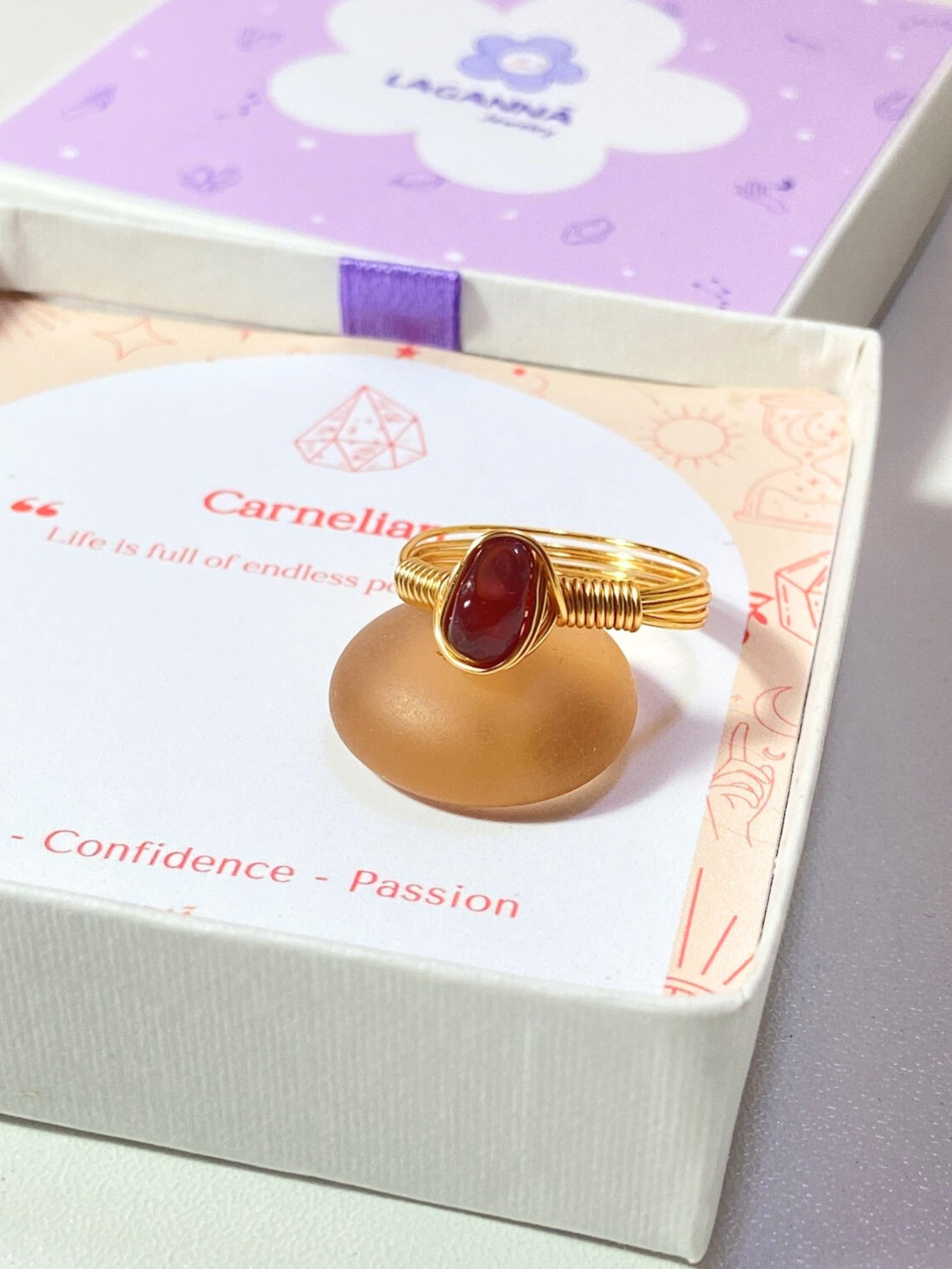 Handmade carnelian irregular stone ring in gold wire wrapped design on elegant jewelry box featuring natural healing crystal jewelry crafted by Sri Lankan artisans as creativity stone ring and sacral chakra balancing amulet for women seeking courage and motivation with raw orange gemstone energy