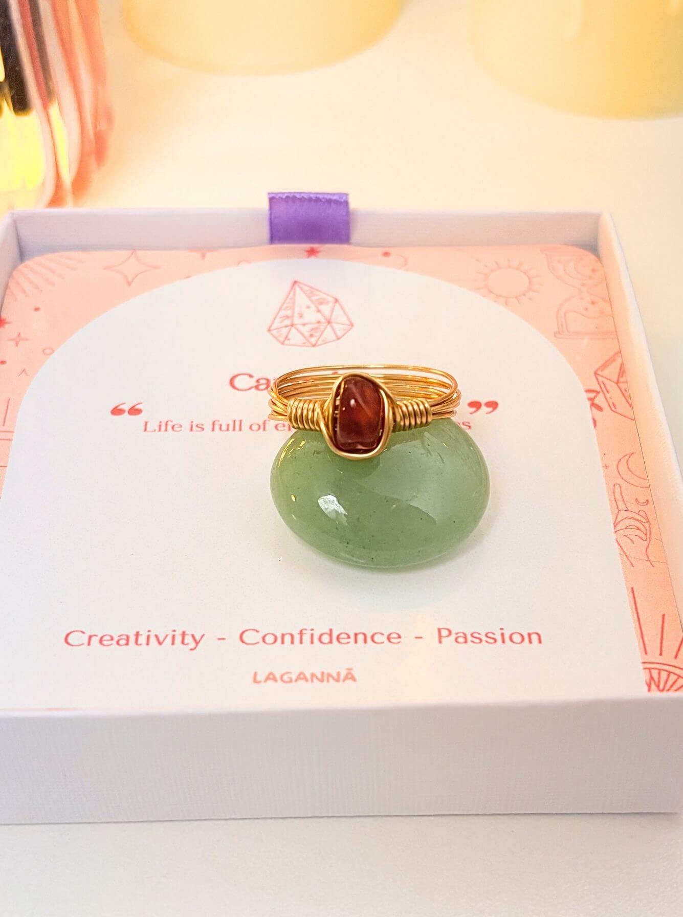 Carnelian Irregular Stone Ring gold wire wrapped displayed on green stone in Laganna jewelry box, handmade healing crystal ring Sri Lanka – creativity confidence passion