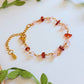 Chinese Red Lantern Bracelet carnelian and rose quartz chip stones gold wire wrapped overhead flat lay with green leaves and rattan prop, handmade healing crystal bracelet Sri Lanka – good fortune motivation love Laganna