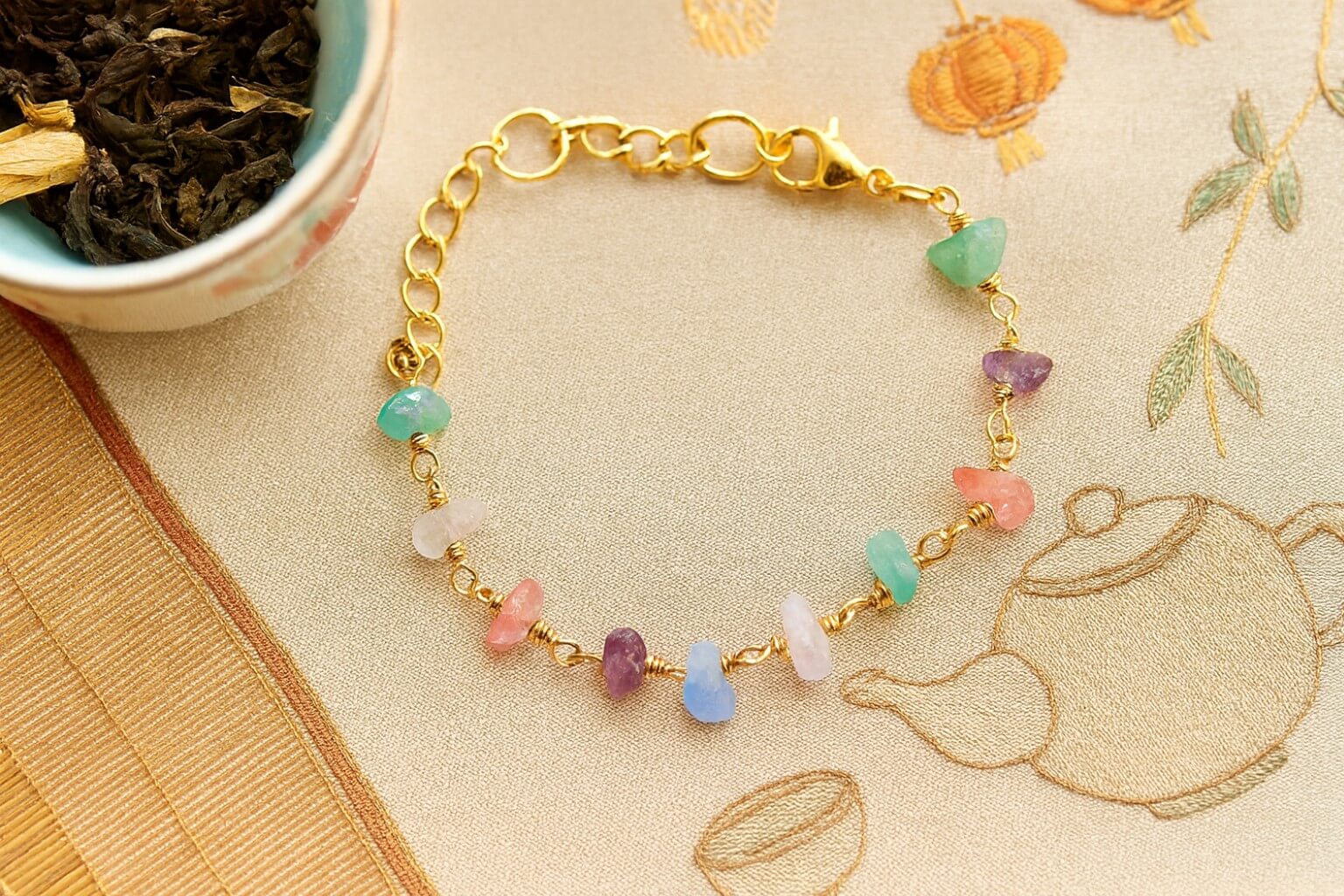 Chinese Tea House Bracelet with healing crystals displayed on traditional silk with tea ceremony elements