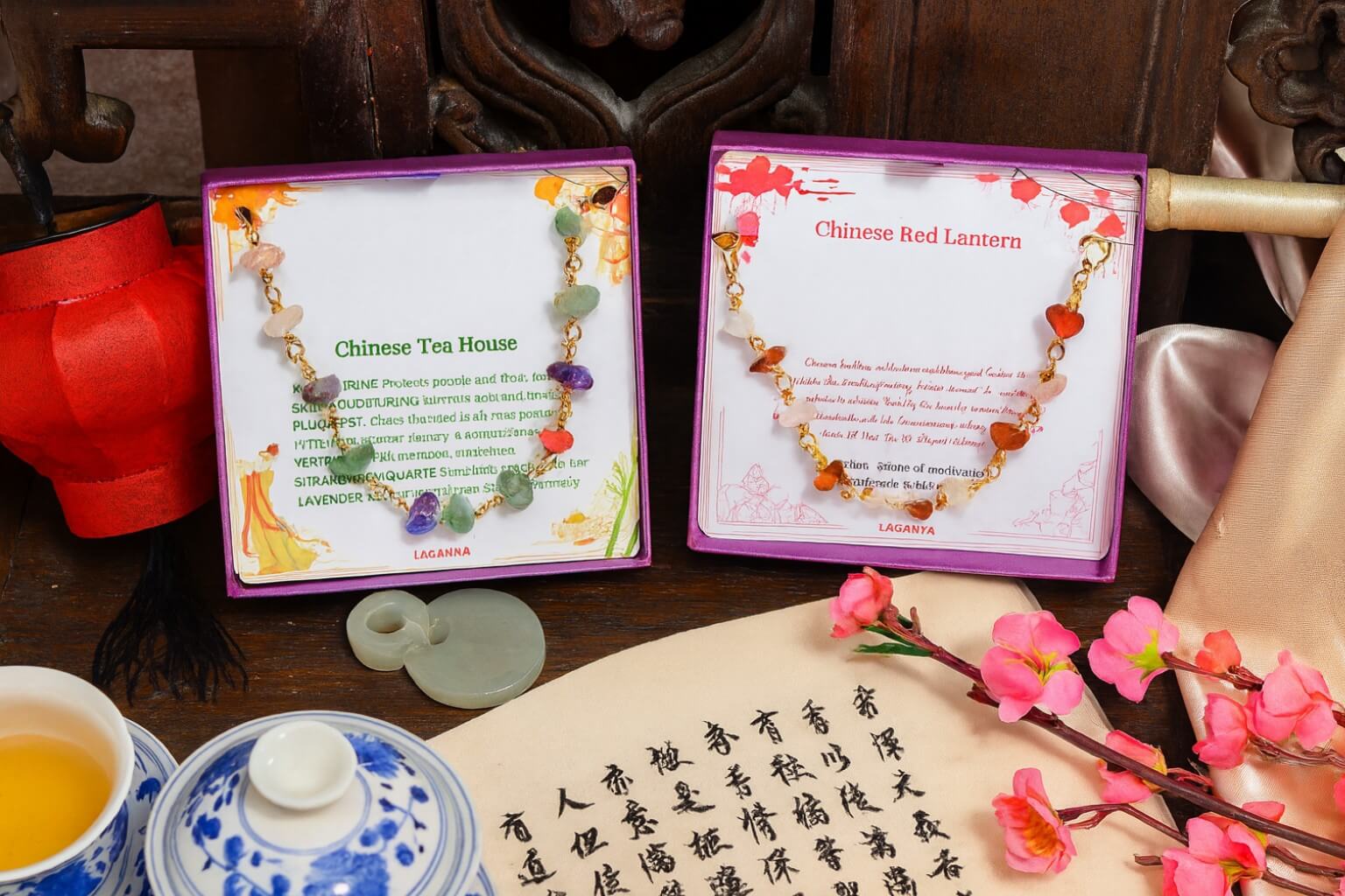 Two jewelry boxes with necklaces labeled 'Chinese Tea House' and 'Chinese Red Lantern' on a table with tea set and flowers.