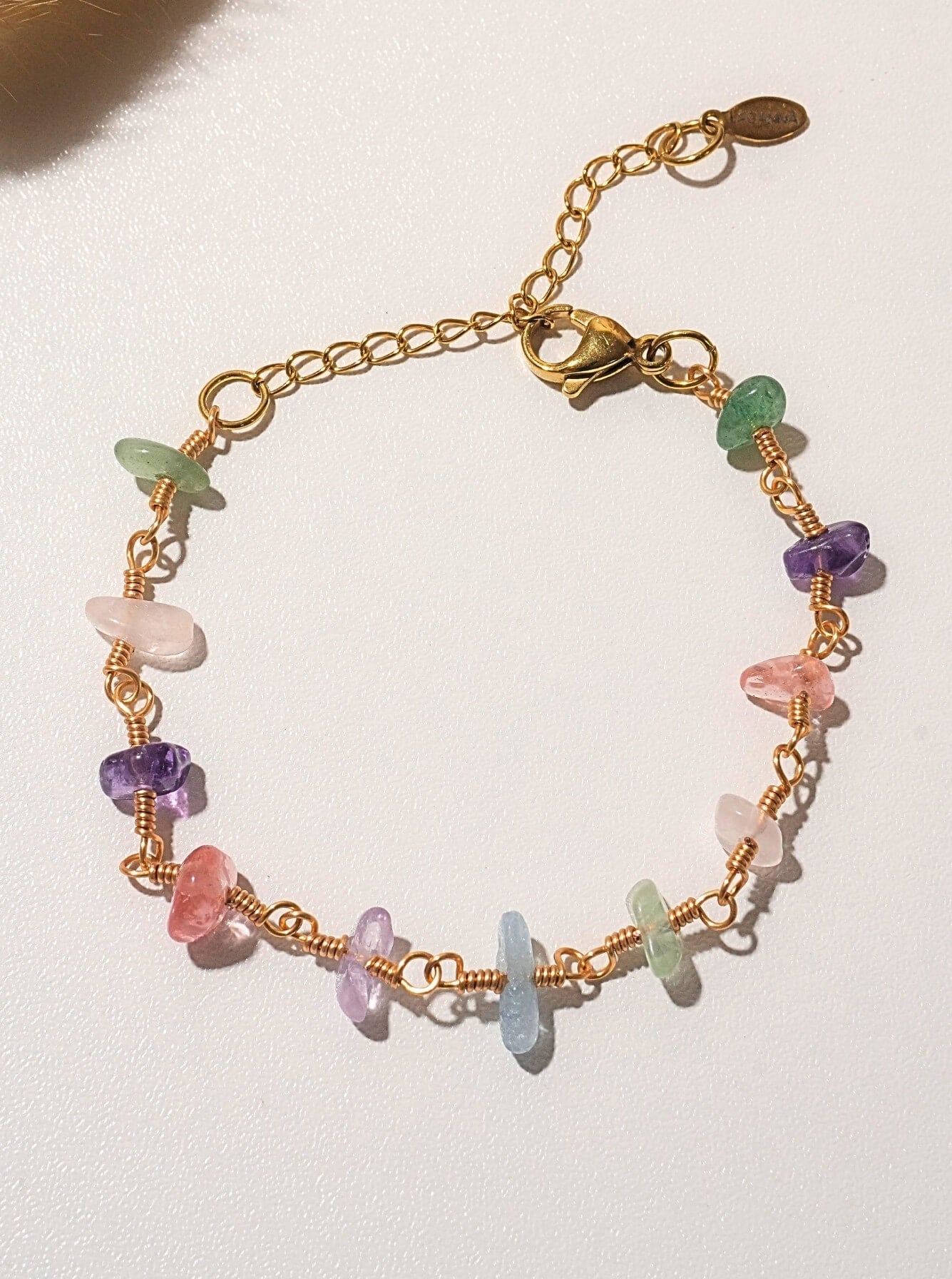 Chinese Tea House Bracelet overhead flat lay showing wire wrapped rose quartz amethyst green aventurine aquamarine fluorite purple jade crystal chips on gold chain, handmade healing crystal bracelet Sri Lanka – Laganna
