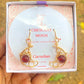 Crescent moon dangle earrings with carnelian in jewelry box, handmade Sri Lankan gold wire wrapped celestial earrings for confidence and motivation