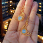 Stunning Crescent Moon Dangle Earrings showcasing Opalite's ethereal glow, handmade gold wire wrapped celestial jewelry from Sri Lanka by Laganna, shown on hands as mystical bohemian accessories