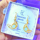 Close-up of Crescent Moon Dangle Earrings with Opalite healing crystals, handmade gold wire wrapped celestial jewelry from Sri Lanka by Laganna, beautifully packaged as meaningful spiritual gifts
