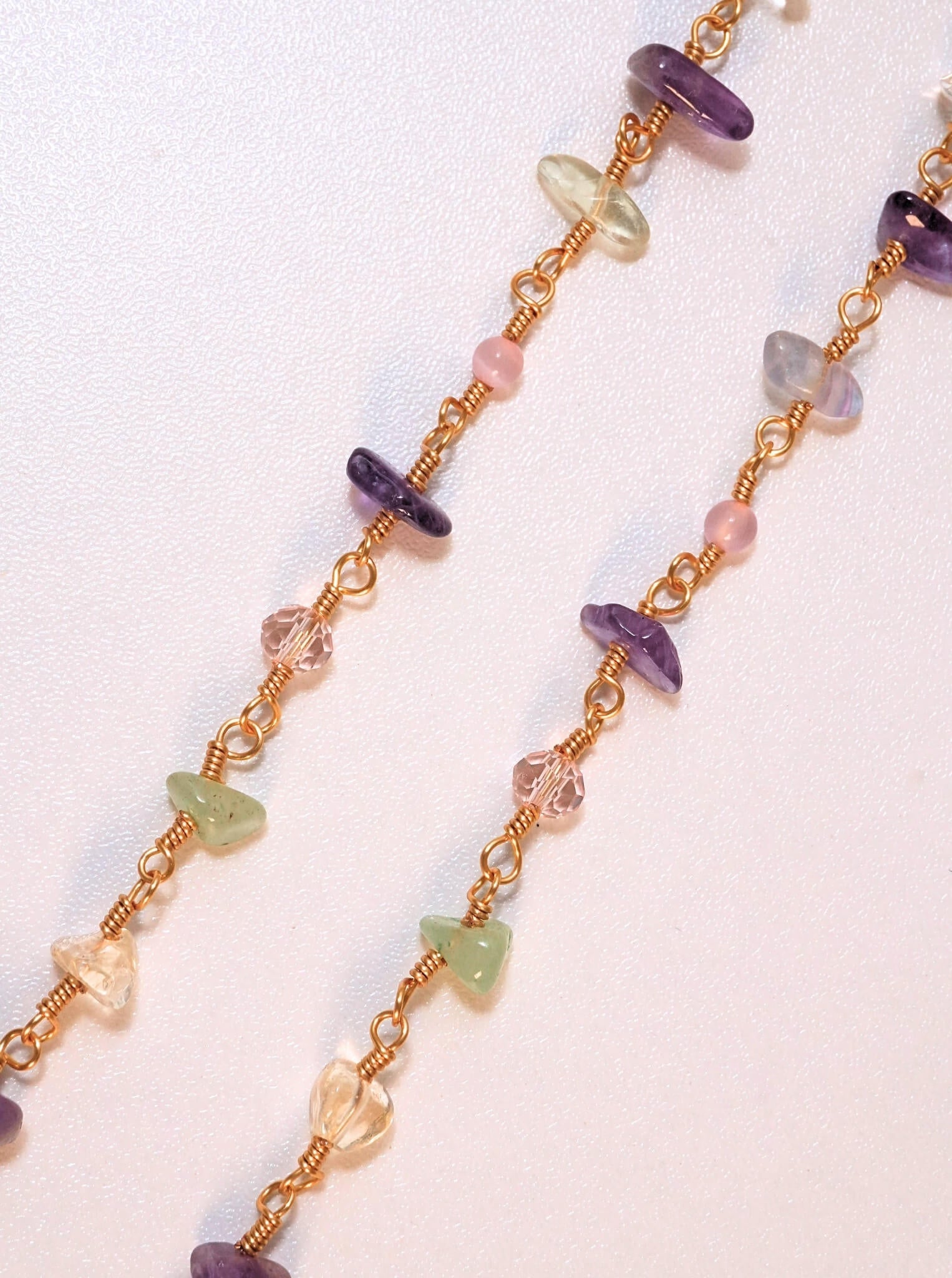 Close-up detail of Crystal Garden Eyeglass Chain showing wire wrapped amethyst green aventurine rose quartz and citrine healing crystal chips on gold chain, handmade jewelry Sri Lanka – Laganna