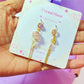 Crystal Planet mismatched dangle earrings jewelry card held on hand, handmade Sri Lankan rose quartz and citrine gold wire wrapped earrings gift