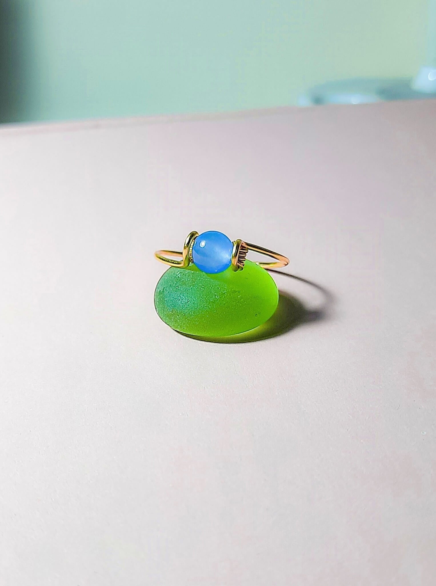 Dainty round blue chalcedony ring in gold wire wrap, handmade Sri Lankan healing crystal ring for throat chakra and communication enhancement