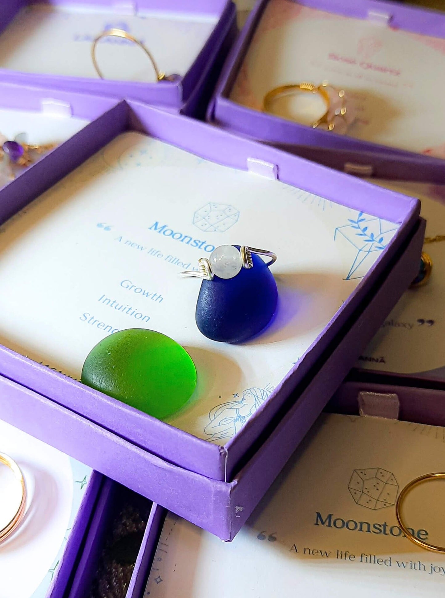 Dainty round moonstone ring in silver wire wrap jewelry box closeup, handmade Sri Lankan healing crystal ring for crown chakra and emotional balance