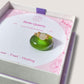 Dainty round rose quartz ring jewelry box on light background, handmade Sri Lankan gold wire wrapped healing crystal ring for emotional healing