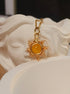 Eternal Sun Necklace Yellow Onyx gold wire sun pendant resting on white goddess sculpture artistic flat lay, handmade healing crystal necklace Sri Lanka Laganna