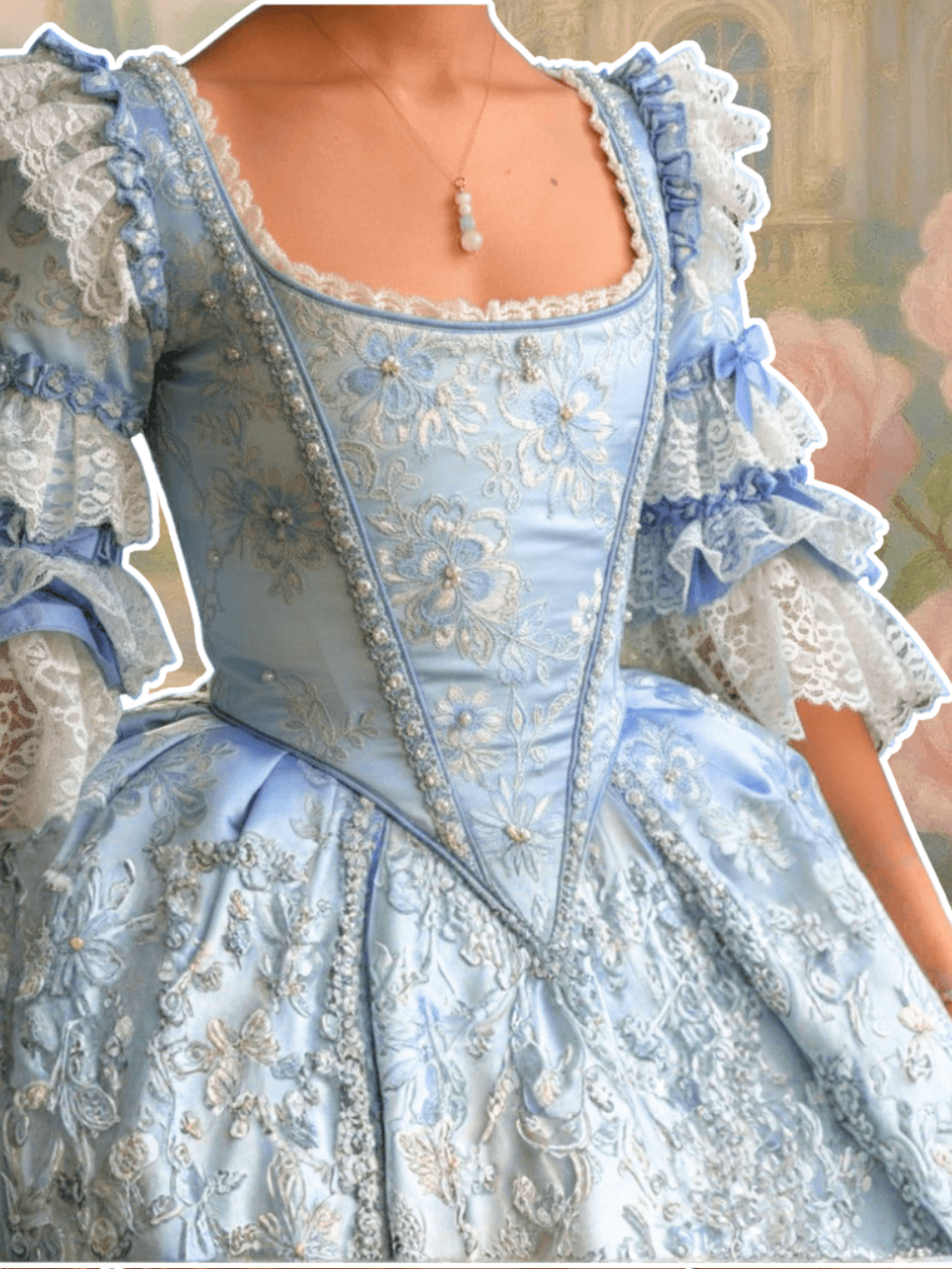 Close-up of a light blue embroidered dress with intricate details wearing french palace column necklace