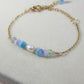 Side view of Freshwater Lake Bracelet showing gold wire wrapped crystals in serene water palette colors, handmade jewelry from Sri Lanka