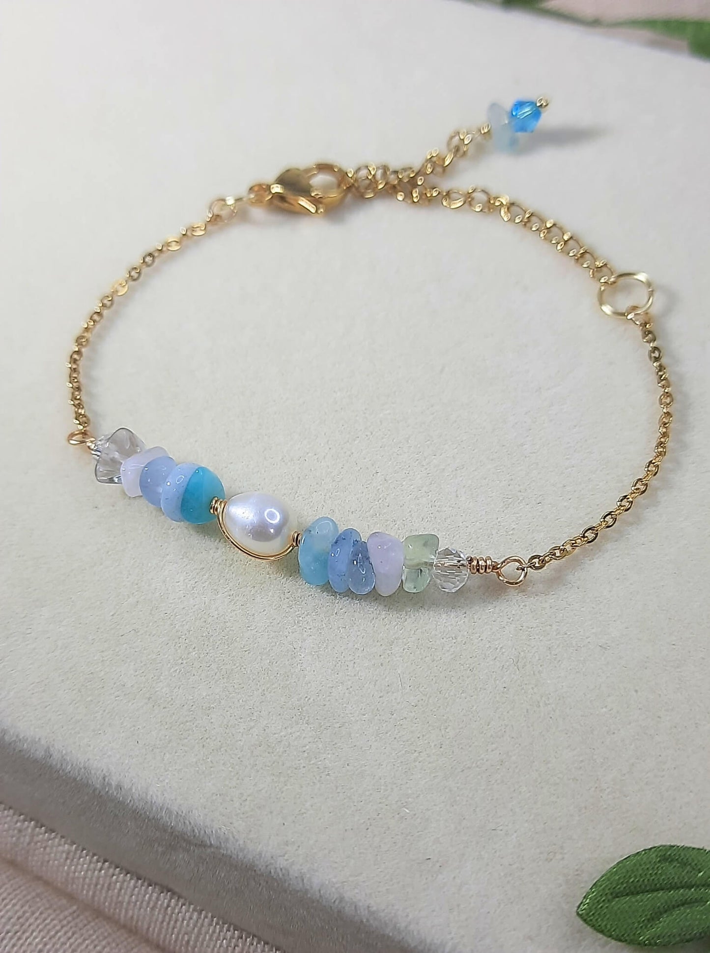 Side view of Freshwater Lake Bracelet showing gold wire wrapped crystals in serene water palette colors, handmade jewelry from Sri Lanka