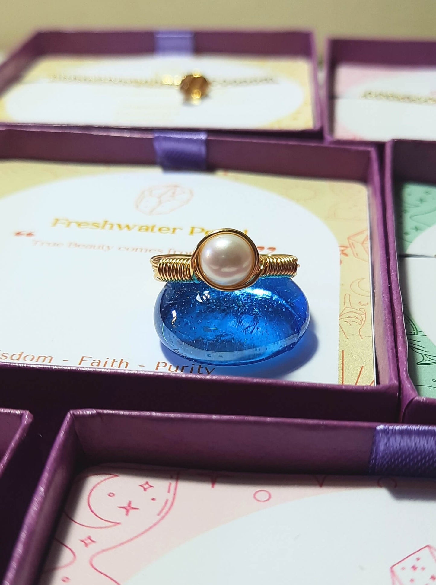  Natural freshwater pearl ring jewelry box closeup showing gold wire wrapped design, handmade Sri Lankan pearl jewelry for purity and emotional balance