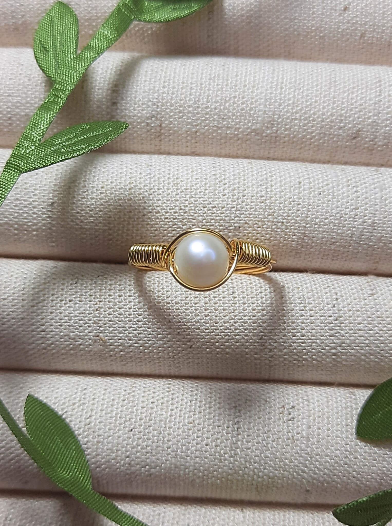 Freshwater pearl ring in gold wire wrapped design on jewelry display, handmade Sri Lankan pearl jewelry for purity and emotional balance