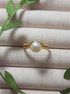 Freshwater pearl ring in gold wire wrapped design on jewelry display, handmade Sri Lankan pearl jewelry for purity and emotional balance