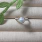 Natural freshwater pearl ring in silver wire wrap on jewelry display, handmade Sri Lankan pearl jewelry for wisdom and calming energy
