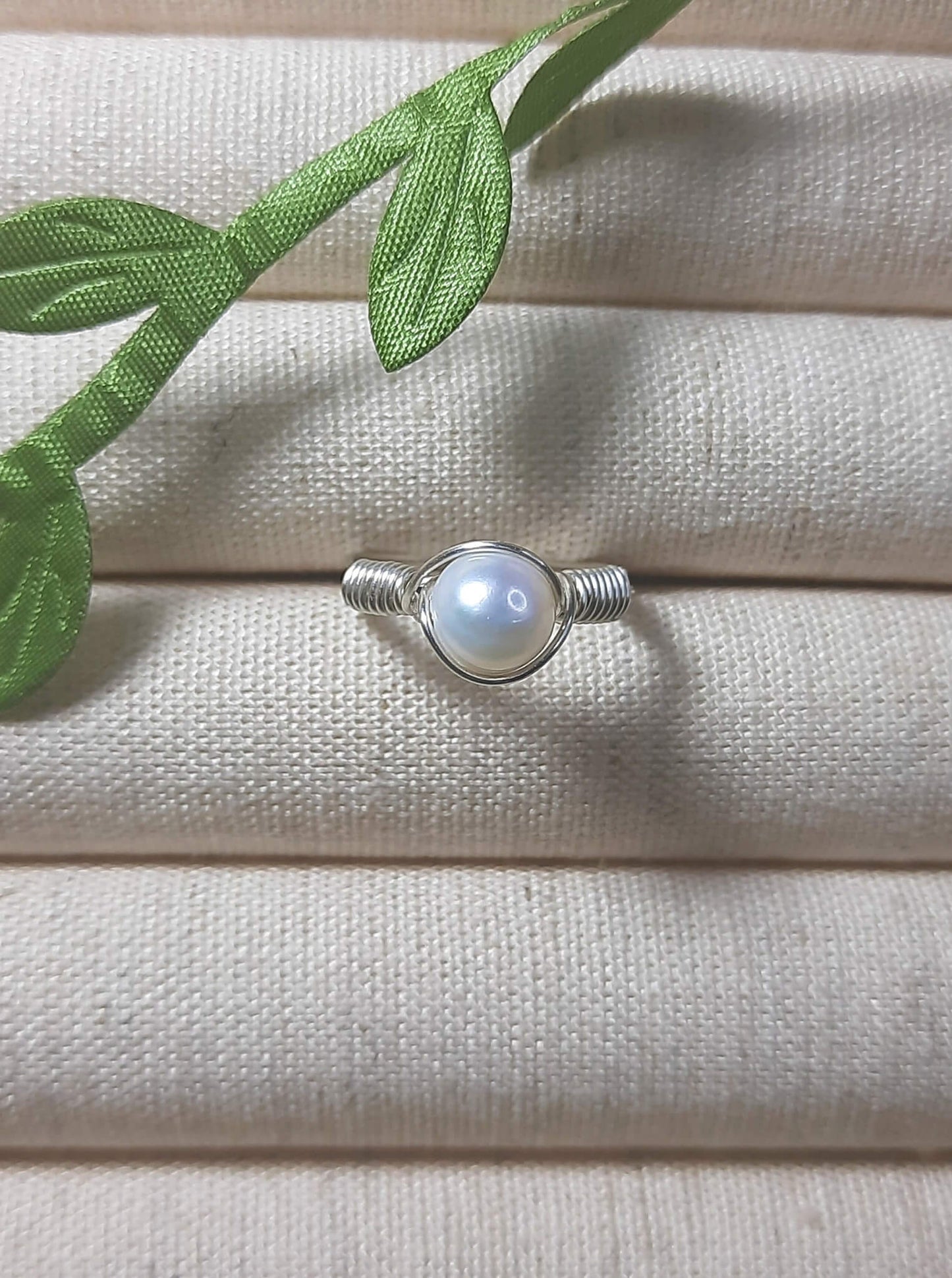 Natural freshwater pearl ring in silver wire wrap on jewelry display, handmade Sri Lankan pearl jewelry for wisdom and calming energy