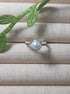 Natural freshwater pearl ring in silver wire wrap on jewelry display, handmade Sri Lankan pearl jewelry for wisdom and calming energy